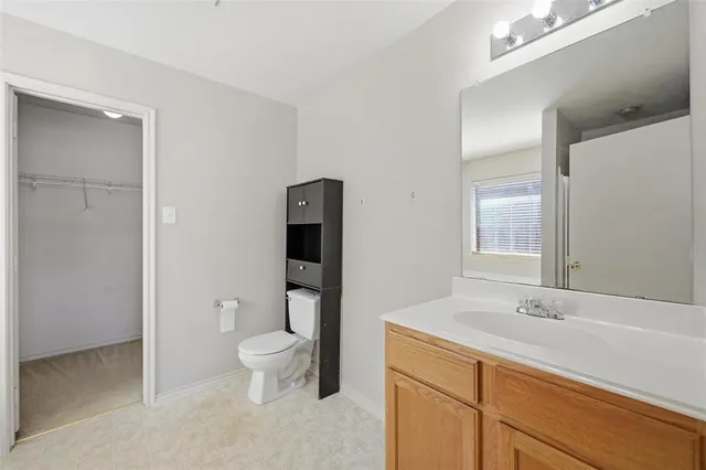 a spacious bathroom with a toilet sink and a mirror