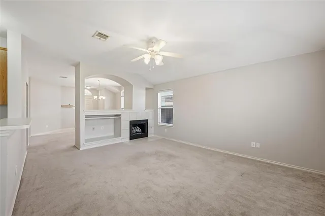 an empty room with fireplace and windows