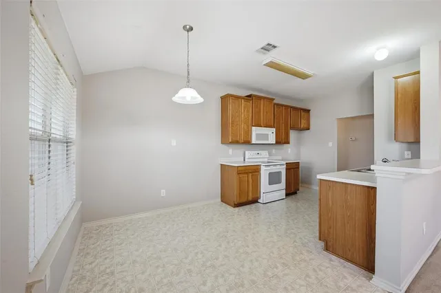 a kitchen with stainless steel appliances granite countertop a sink a stove top oven a counter space and cabinets