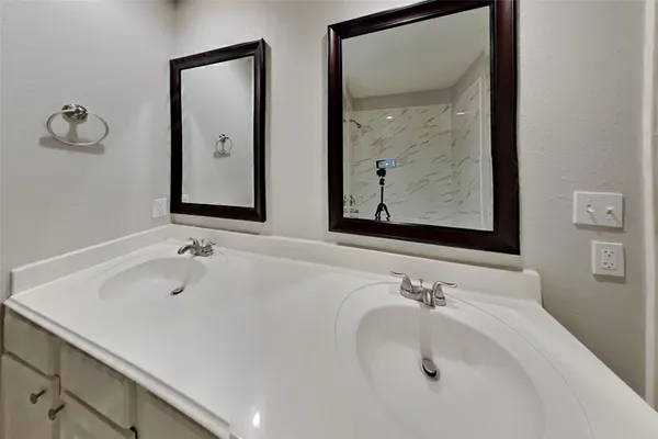 a bathroom with 2 sink and a mirror