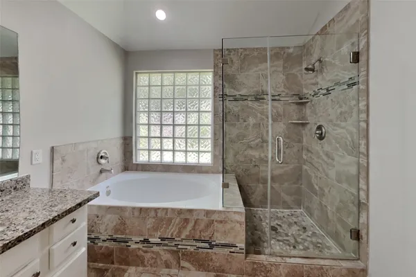 a bathroom with a granite countertop sink a toilet and shower