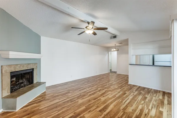 a view of empty room with wooden floor and fireplace