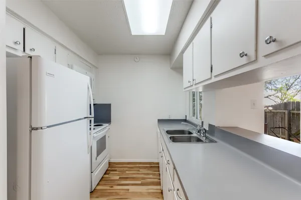 a view of a kitchen with a sink and refrigerator