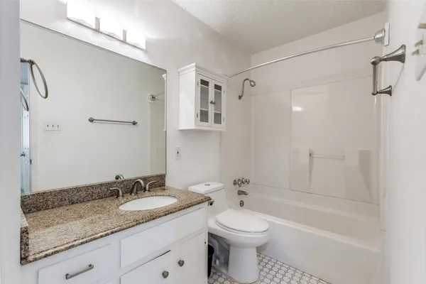a bathroom with a granite countertop sink toilet and shower