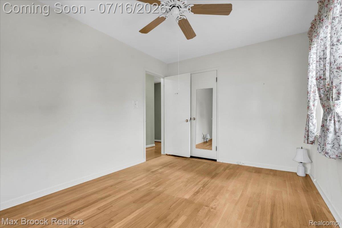 1292 Yorkshire Road Birmingham, MI 48009 - Photo 24 of 47 Hardwood flooring throughout, with a ceiling fan and a window featuring floral curtains