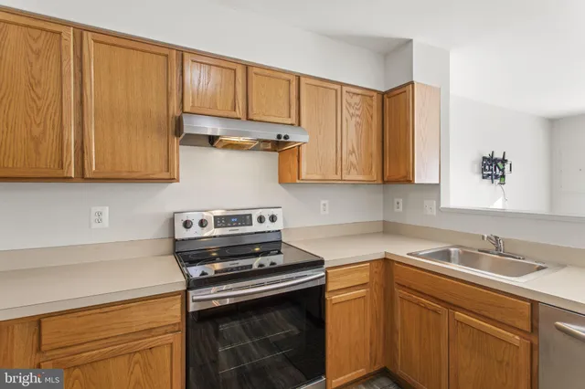 a kitchen with stainless steel appliances granite countertop a sink stove and cabinets
