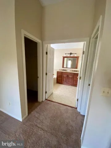 a view of a hallway view with wooden floor and a living room