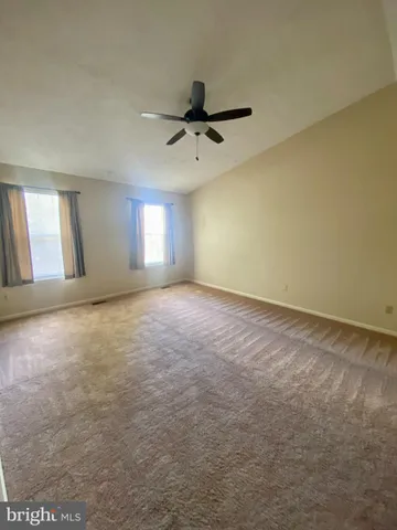 an empty room with windows and fan view