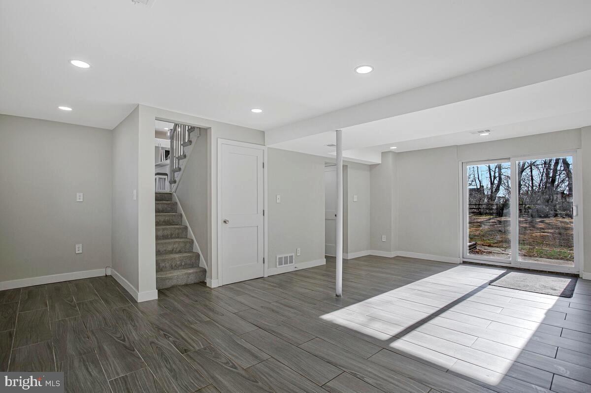 735 Whitehall Beach Road Annapolis, MD 21409 - Photo 20 of 35 a view of an empty room with wooden floor and stairs