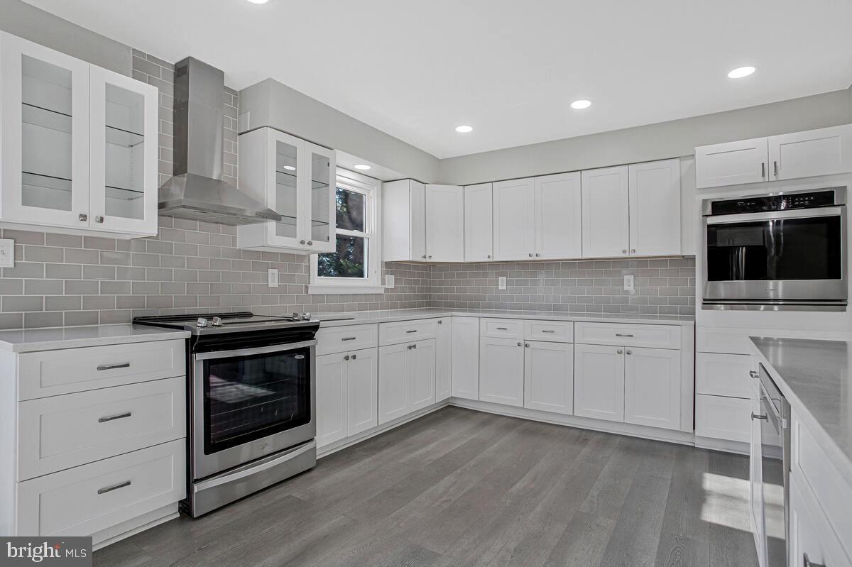 735 Whitehall Beach Road Annapolis, MD 21409 - Photo 7 of 35 a kitchen with granite countertop white cabinets stainless steel appliances and sink