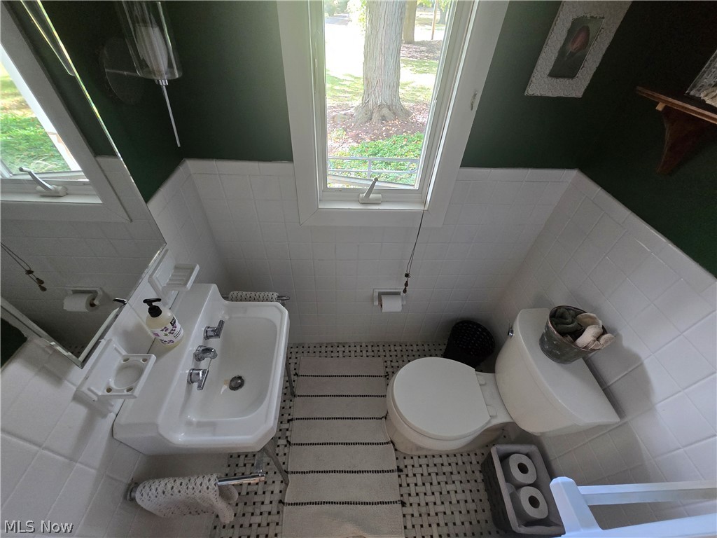 4639 Brainard Road Chagrin Falls, OH 44022 - Photo 35 of 50 Half bath showing a window to the front of home, ceramic white tile, and ceramic flooring.