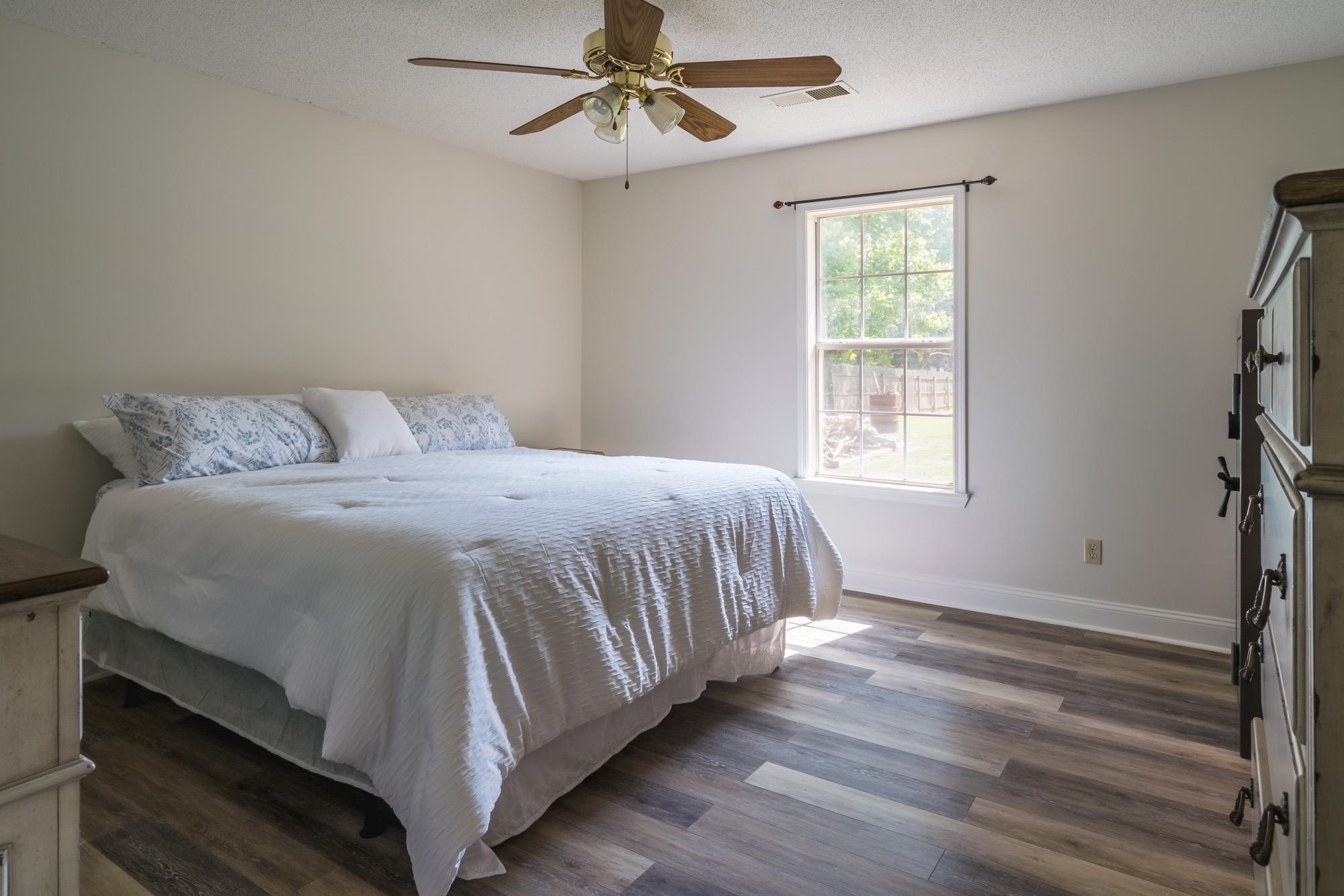 192 Madison Drive Atoka, TN 38004 - Photo 11 of 23 a bedroom with a bed and wooden floor