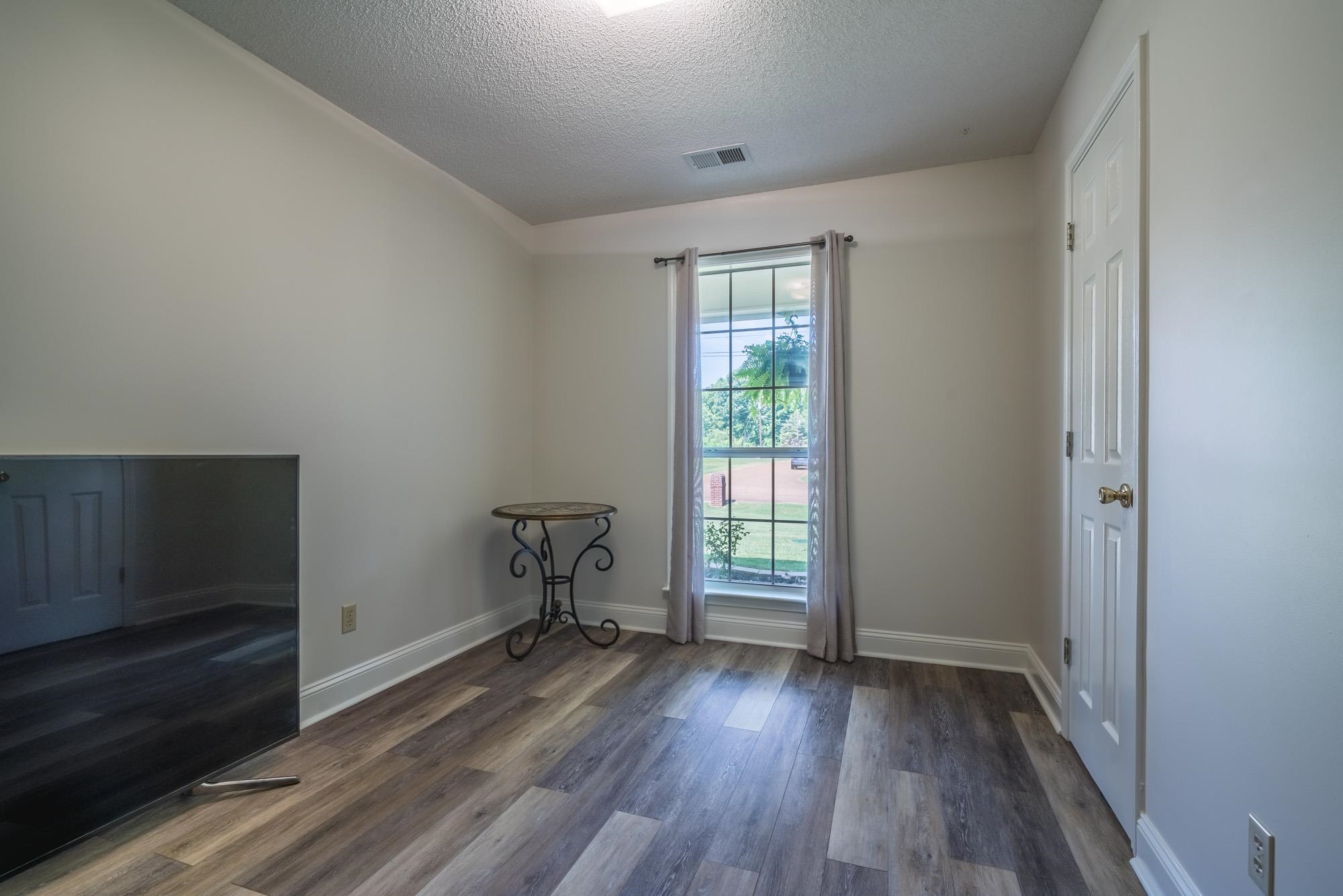 192 Madison Drive Atoka, TN 38004 - Photo 18 of 23 wooden floor in an empty room with a window