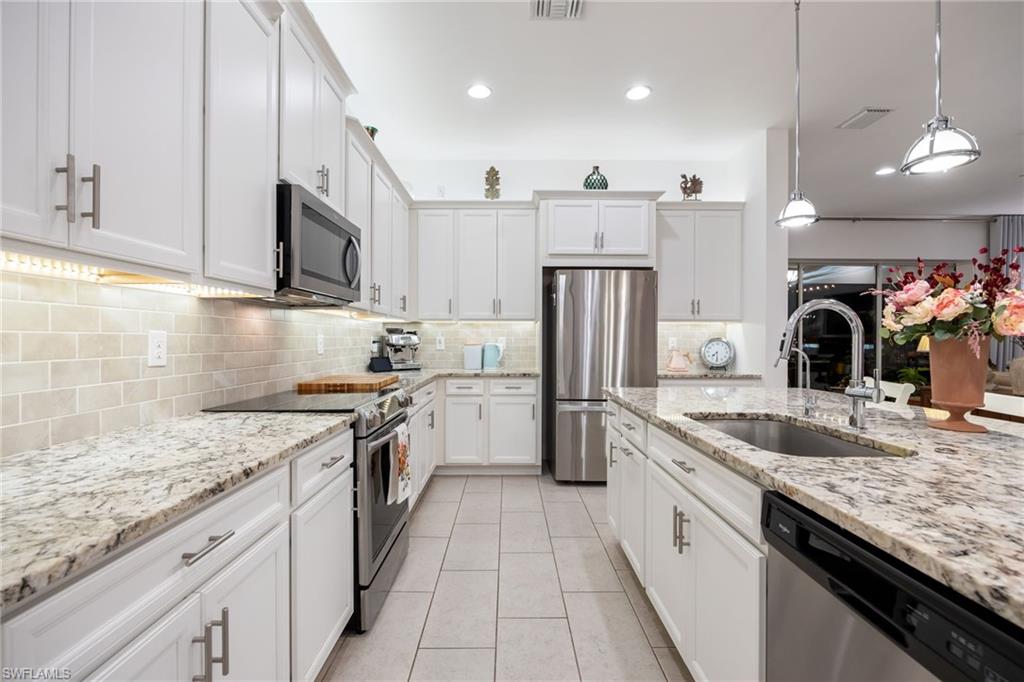 3620 Pilot Circle Naples, FL 34120 - Photo 19 of 49 a kitchen with a sink a refrigerator and cabinets