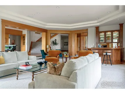 a kitchen with stainless steel appliances granite countertop a refrigerator a sink dishwasher a stove and a dining table with wooden floor