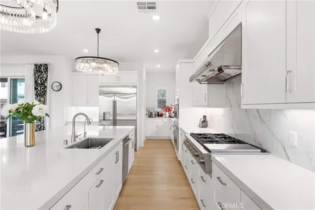 a large kitchen with stainless steel appliances granite countertop a lot of counter space and wooden floor