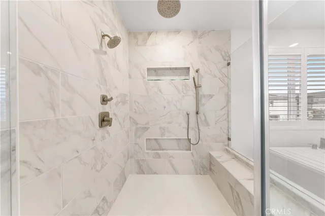 a bedroom with a bed next to a window with a chandelier