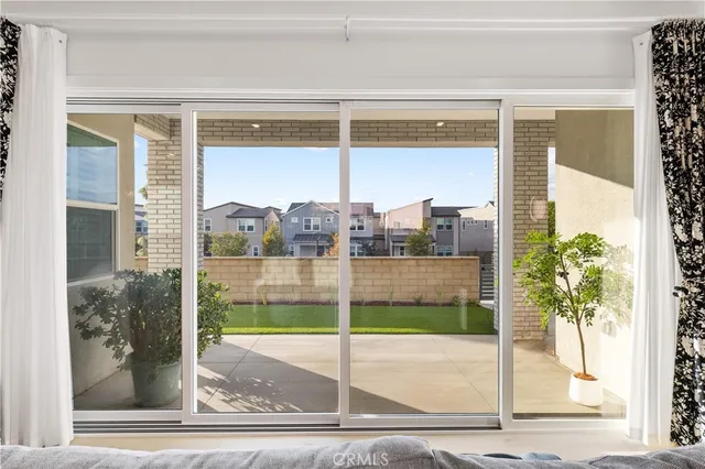 a view of a porch with a floor to ceiling window and potted plants