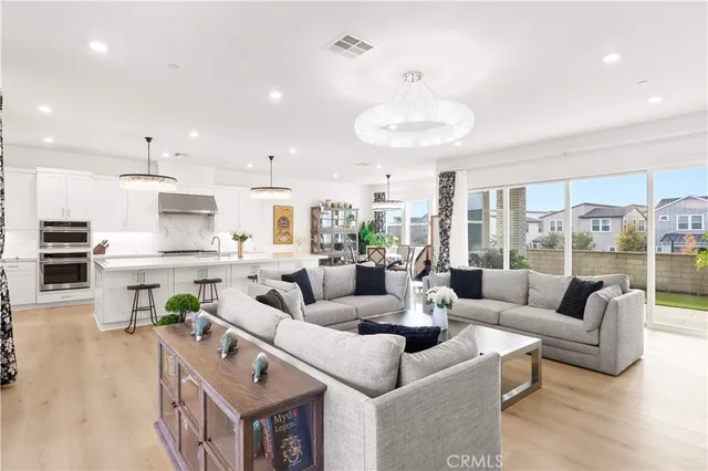 a living room with furniture kitchen and a large window