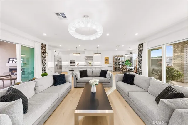 a living room with furniture kitchen view and large windows