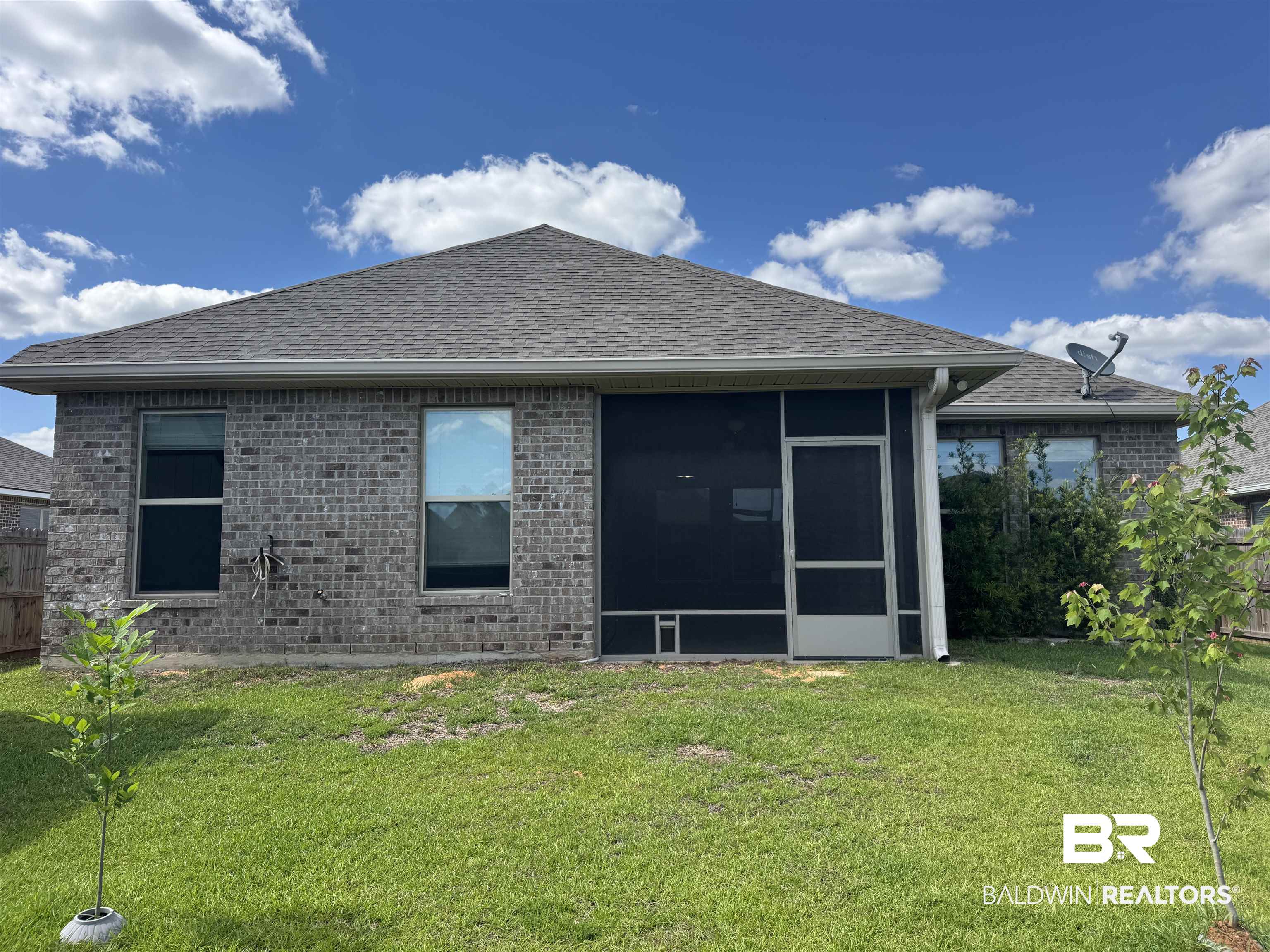 1060 Chloe Street Foley, AL 36535 - Photo 5 of 28 Brick exterior featuring a screened-in patio, dual-pane windows, and a shingled roof