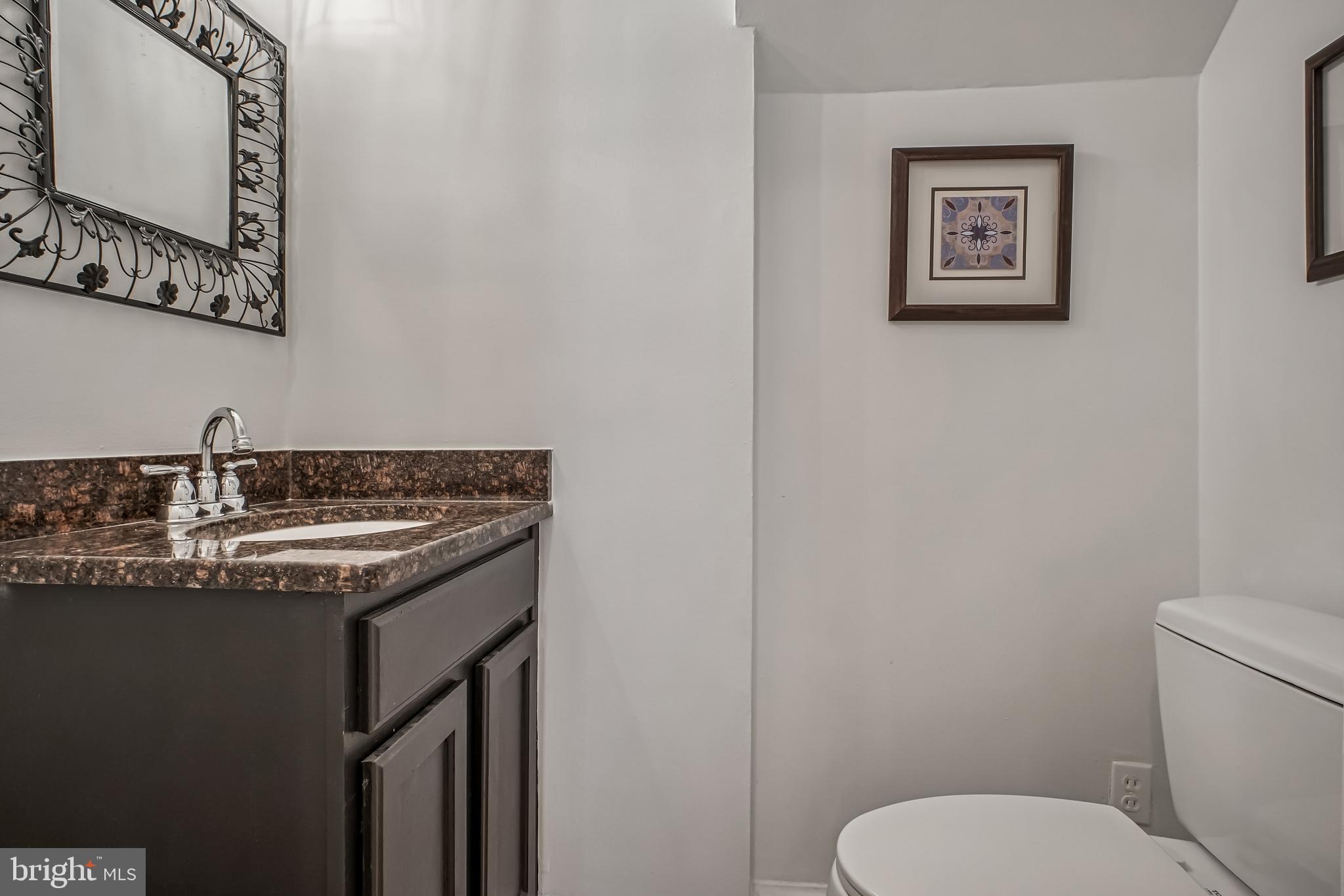 423 20th Street Northeast Washington, DC 20002 - Photo 18 of 35 a bathroom with a granite countertop toilet sink and mirror