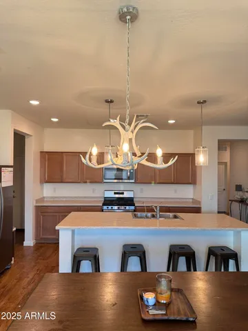 a kitchen with kitchen island granite countertop a stove a sink a refrigerator and a counter top space