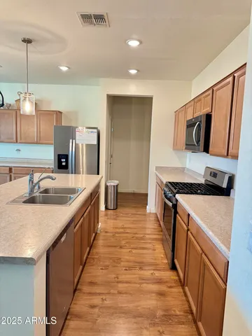 a kitchen with stainless steel appliances granite countertop a sink stove and refrigerator