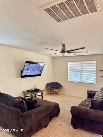a living room with furniture and a ceiling fan