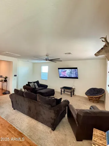 a living room with furniture and a air conditioner vent