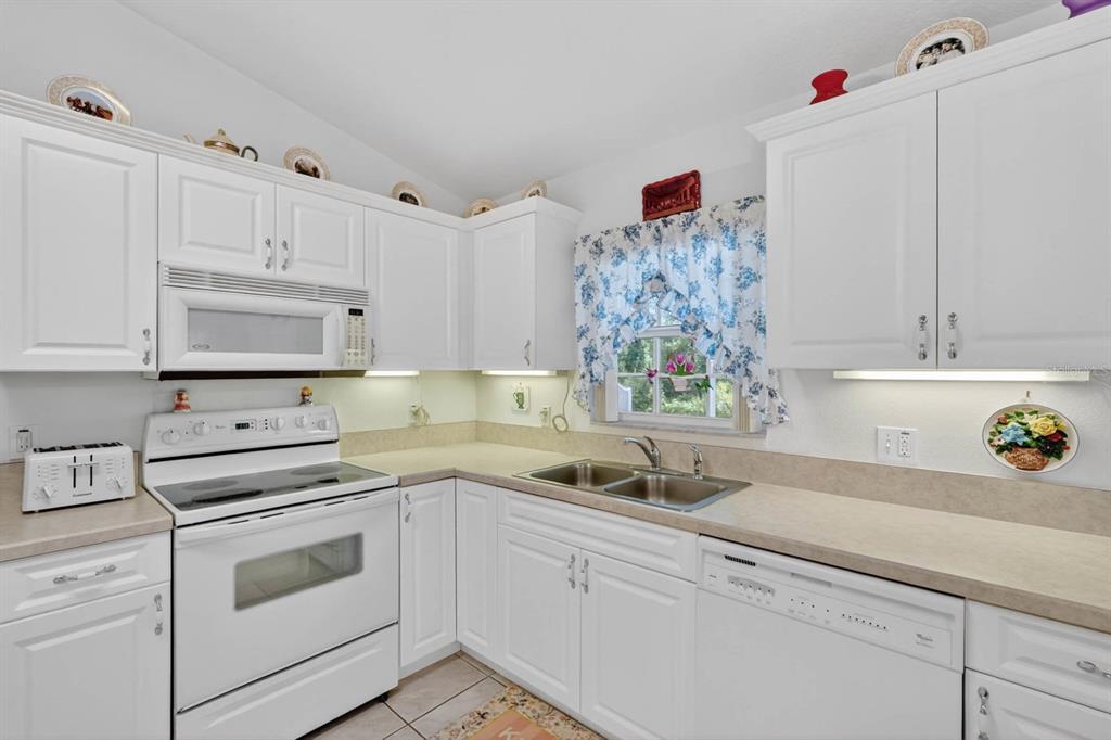 80 Roxboro Drive Palm Coast, FL 32164 - Photo 2 of 39 a kitchen with white cabinets and white appliances