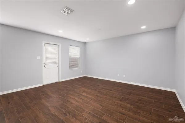 a view of an empty room with wooden floor