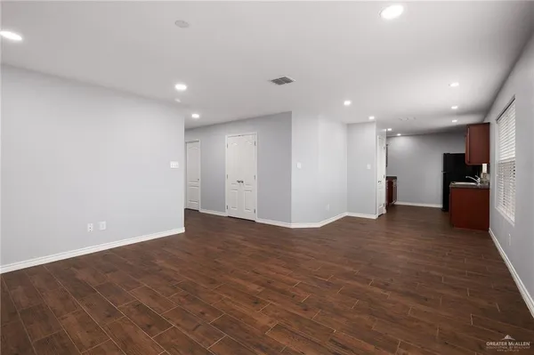 a view of an empty room with a kitchen