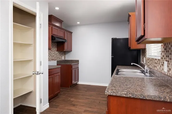 a kitchen with kitchen island granite countertop a sink stove and refrigerator