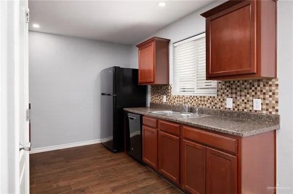 a kitchen with granite countertop a refrigerator and a sink