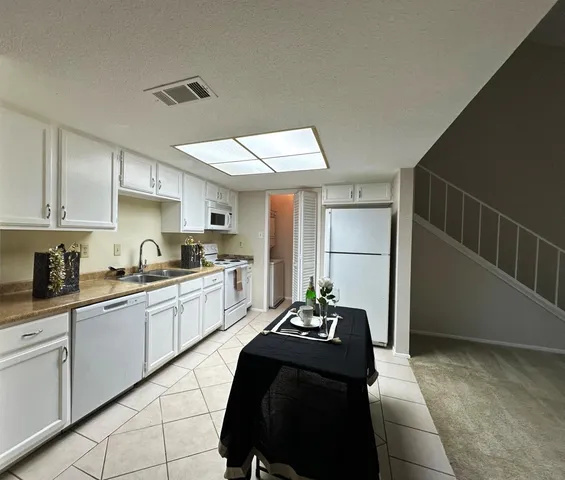 a kitchen with stainless steel appliances kitchen island granite countertop a sink cabinets and wooden floor