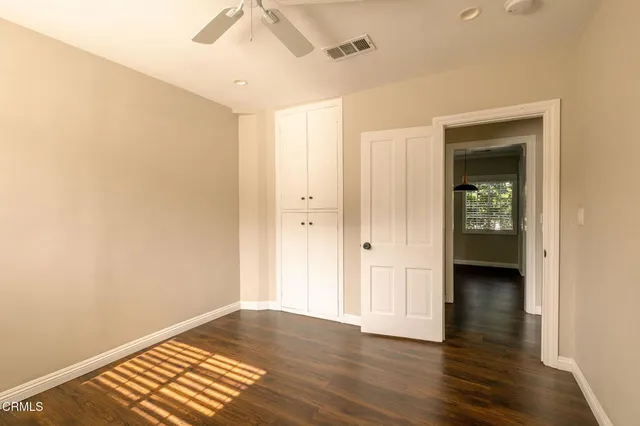 a view of an empty room with wooden floor