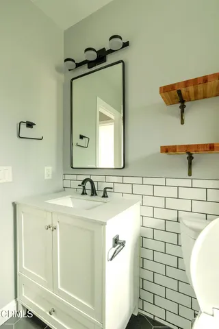 a bathroom with a sink mirror and toilet
