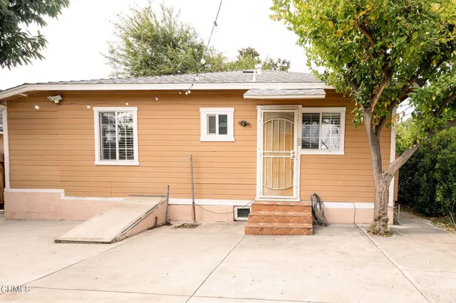 a view of backyard with outdoor seating and wooden fence