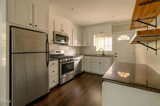 a kitchen with a sink a refrigerator and a stove top oven