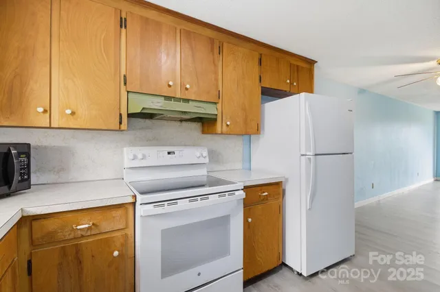a kitchen with a refrigerator sink stove and cabinets
