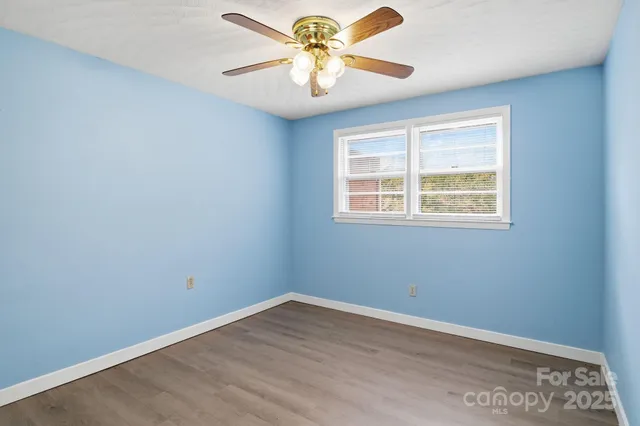 an empty room with a window and a fan