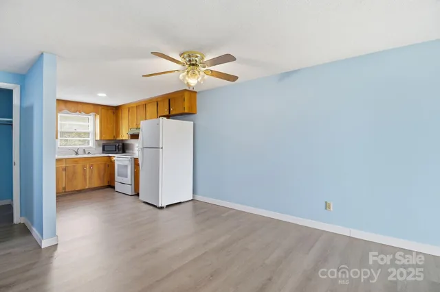 a view of a kitchen with a sink a refrigerator freezer a microwave and cabinets
