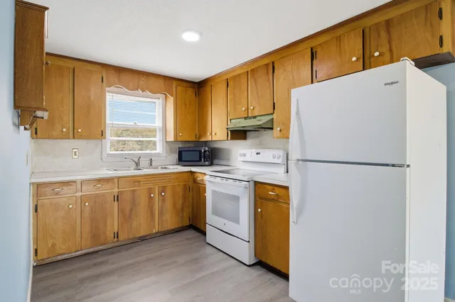a kitchen with stainless steel appliances a refrigerator sink and cabinets
