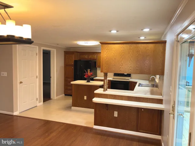 a kitchen with stainless steel appliances a sink a stove a refrigerator a center island and a cabinets