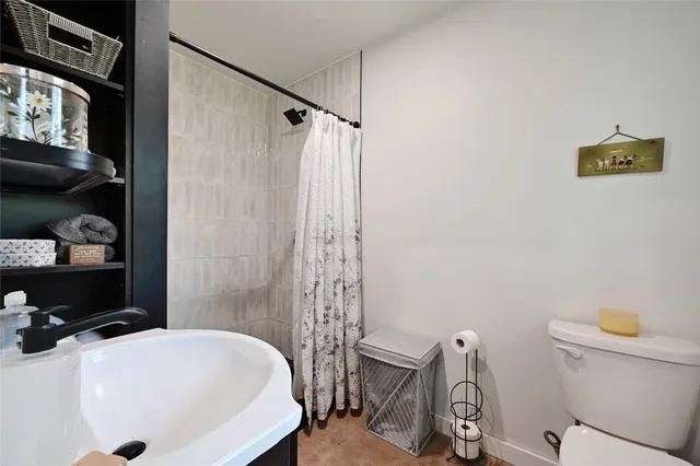 a bathroom with a sink a toilet and shower curtain