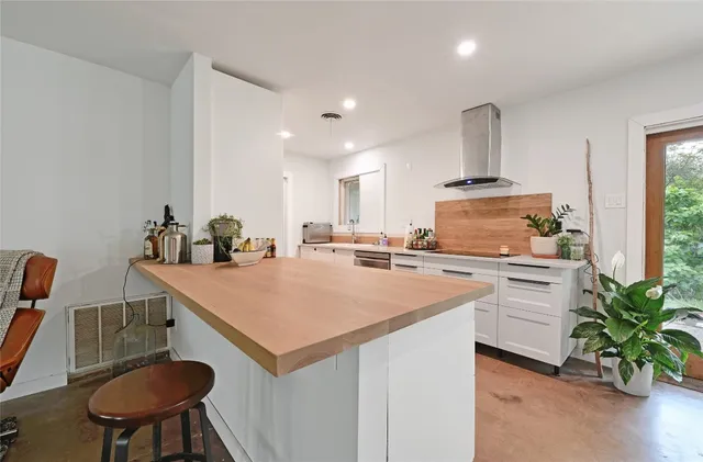 a kitchen with a sink a stove and chairs