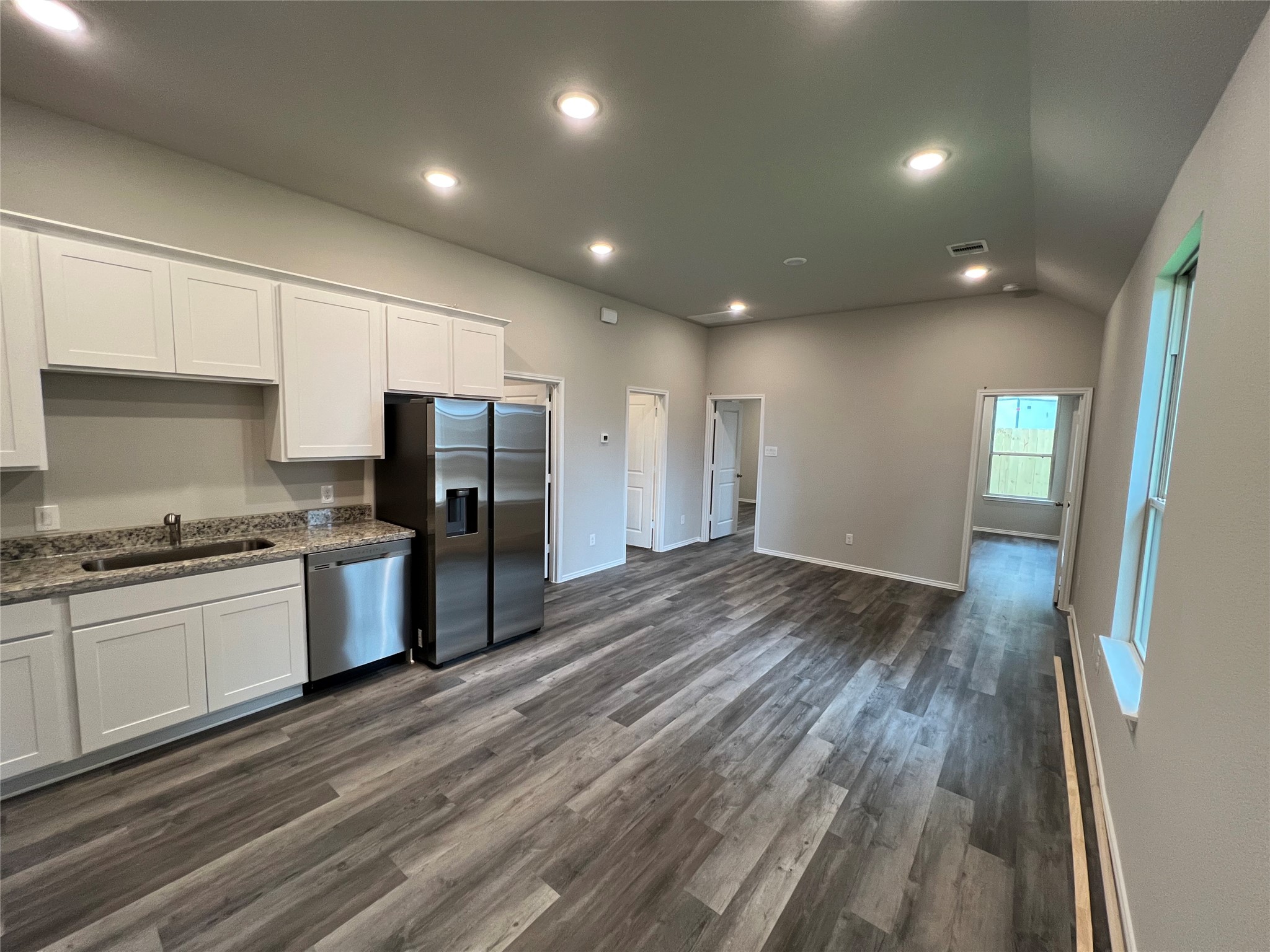 11595 Persimmon Street Willis, TX 77318 - Photo 4 of 14 a kitchen with granite countertop a stove a sink and a refrigerator