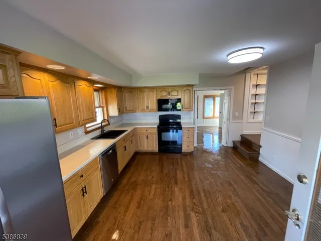 a large kitchen with a lot of counter space and wooden floor