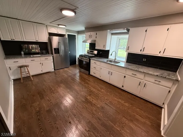 a kitchen with stainless steel appliances a refrigerator sink and microwave